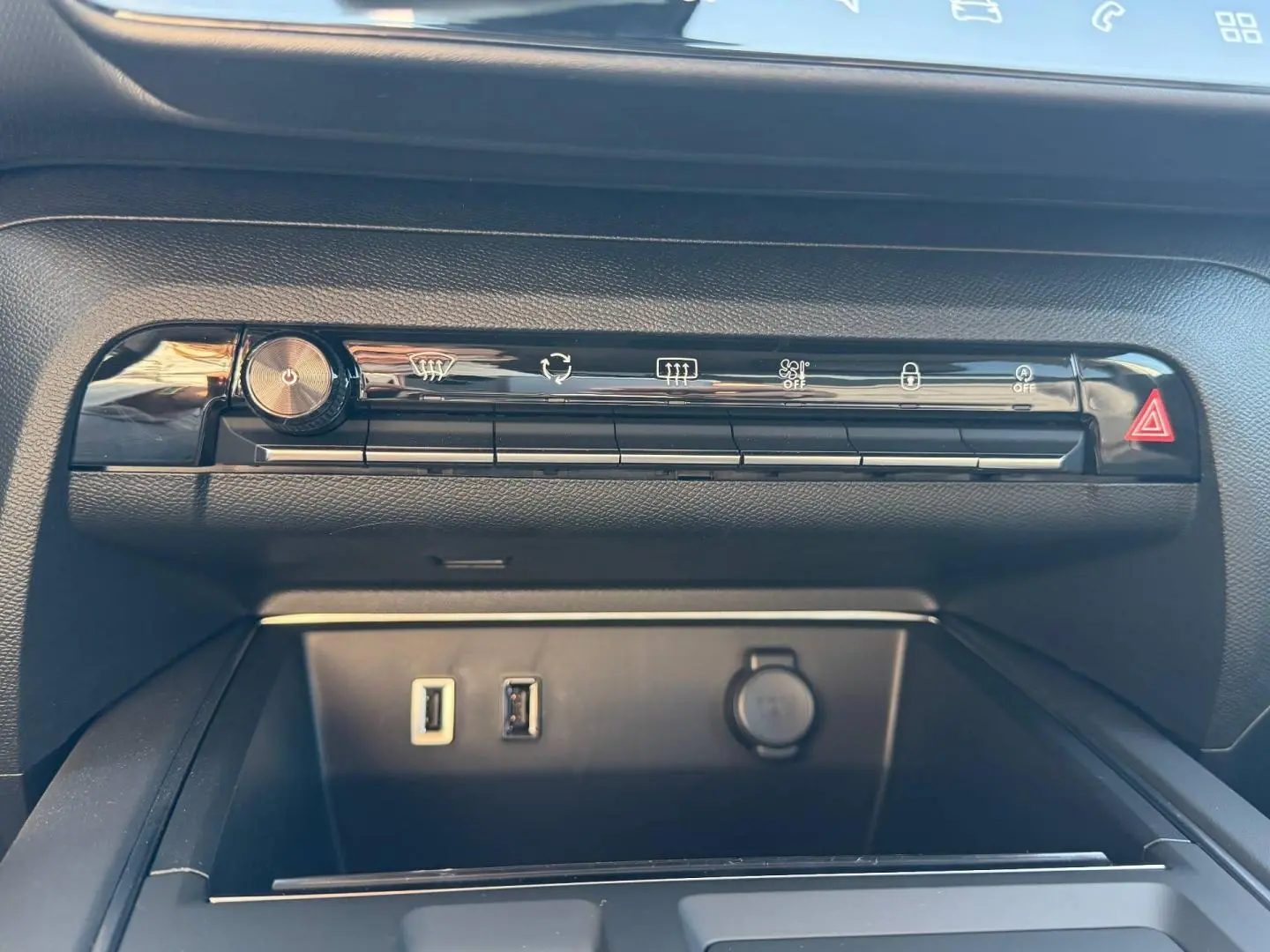 Gros plan sur la console centrale noire du Citroën C5 Aircross 2025 avec boutons de commande et ports USB visibles.