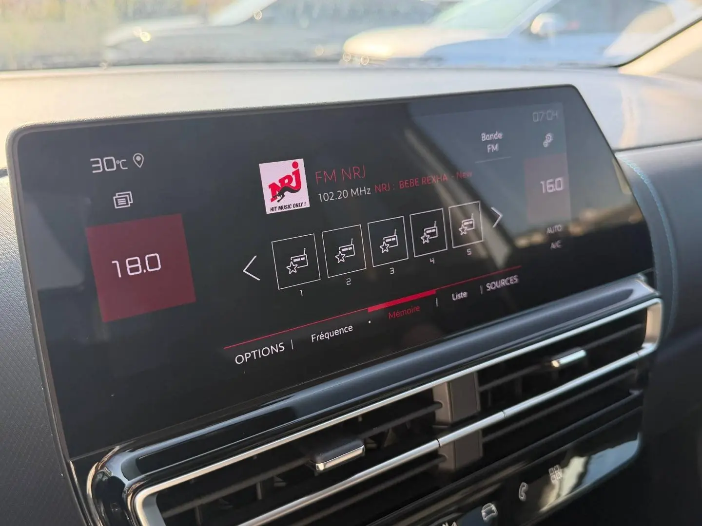 Écran tactile central affichant la radio FM NRJ dans l’habitacle du Citroën C5 Aircross blanc, vue rapprochée.