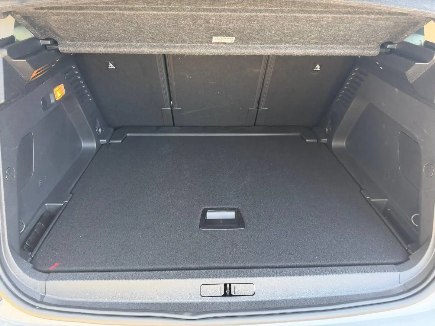 Coffre ouvert du Citroën C5 Aircross blanc Okénite, vue de l'intérieur montrant un plancher de coffre plat et noir.