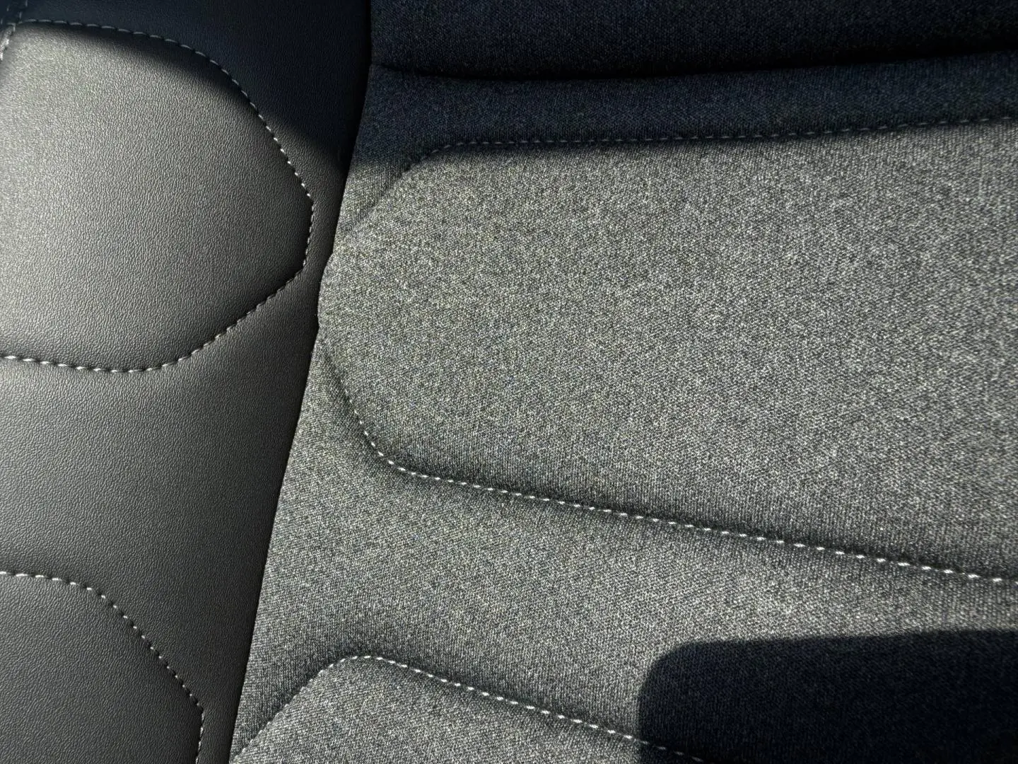 Détail du tissu gris chiné et cuir noir des sièges arrière du Citroën C5 Aircross 2025.