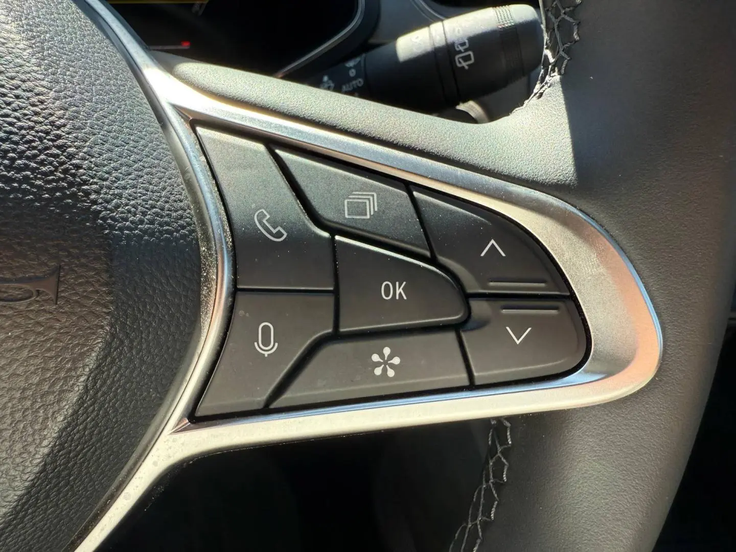 Gros plan sur les commandes multifonctions à droite du volant du Renault Captur 1.6 E-Tech gris Rafale.