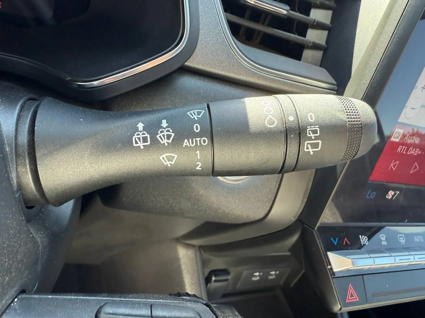 Gros plan sur la commande d'essuie-glace côté gauche du tableau de bord du Renault Captur gris Rafale 2025.
