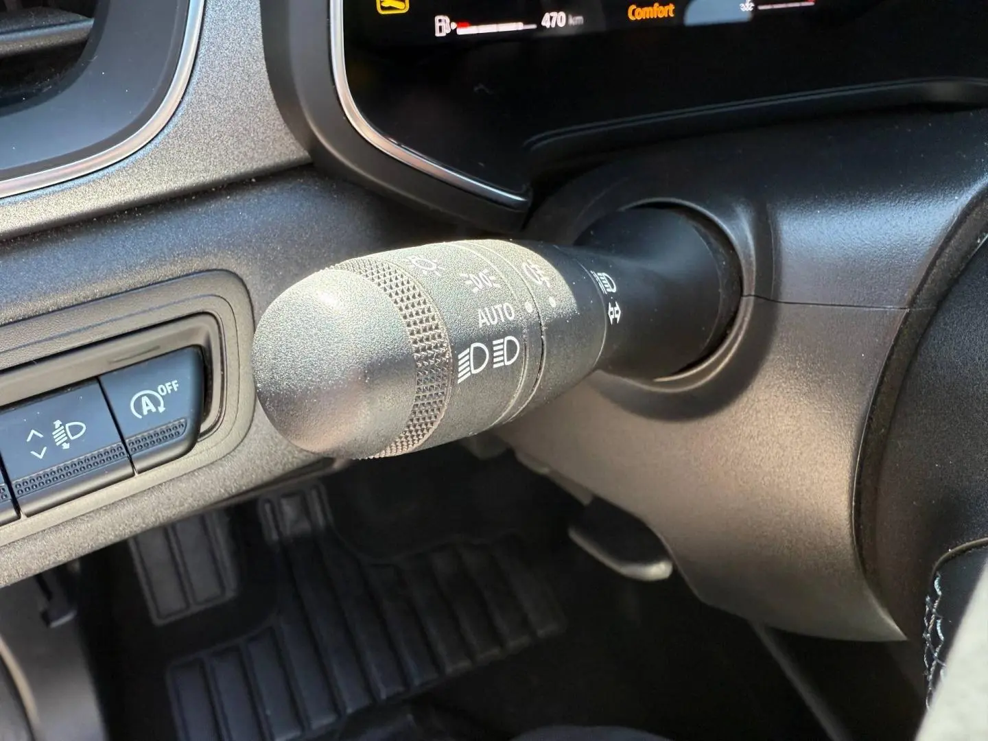 Gros plan sur la commande des phares et essuie-glaces du Renault Captur gris Rafale, tableau de bord partiel visible.