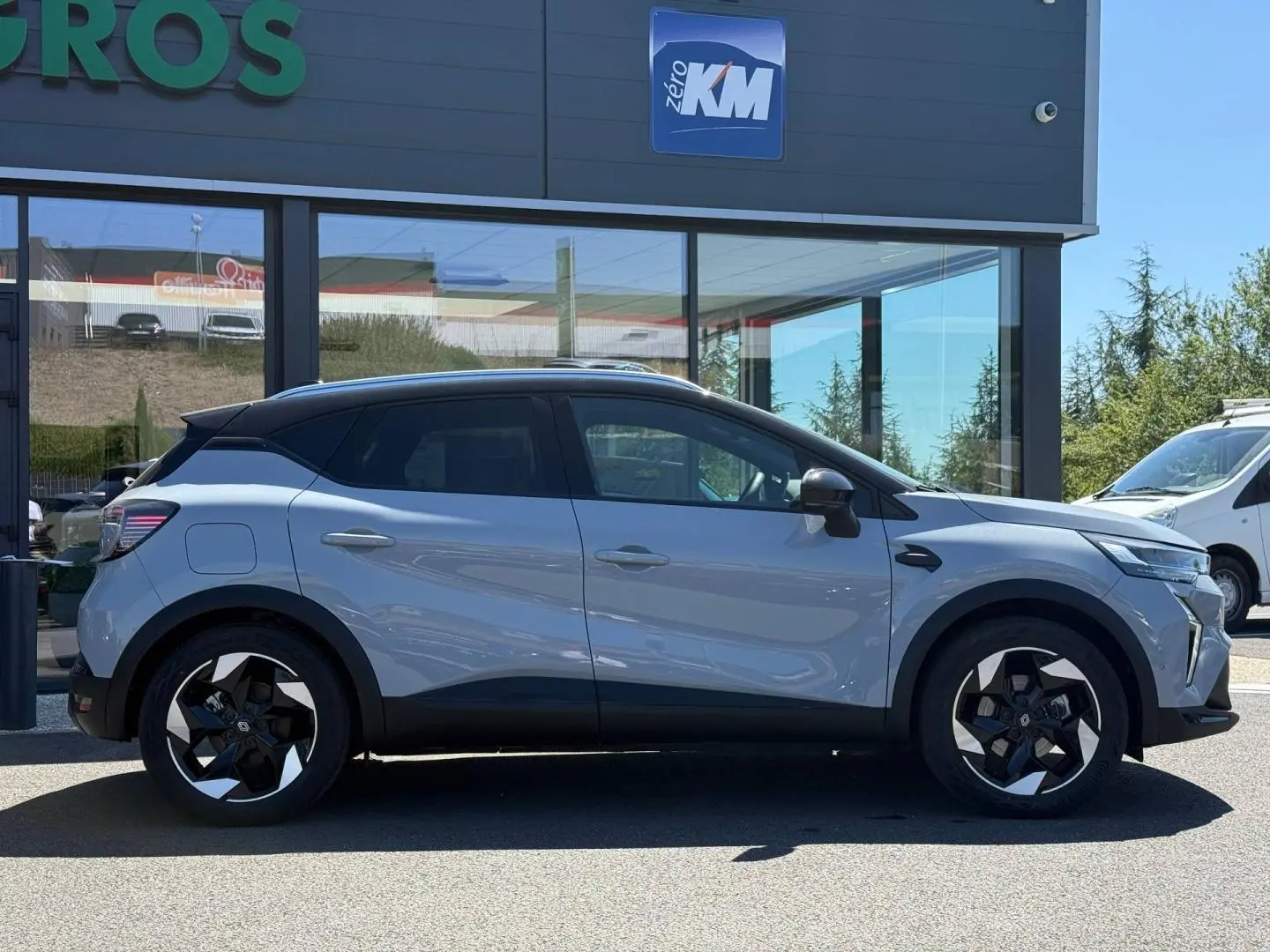Profil droit du Renault Captur 1.6 E-Tech gris Rafale métallisé avec jantes alu noires et toit noir.
