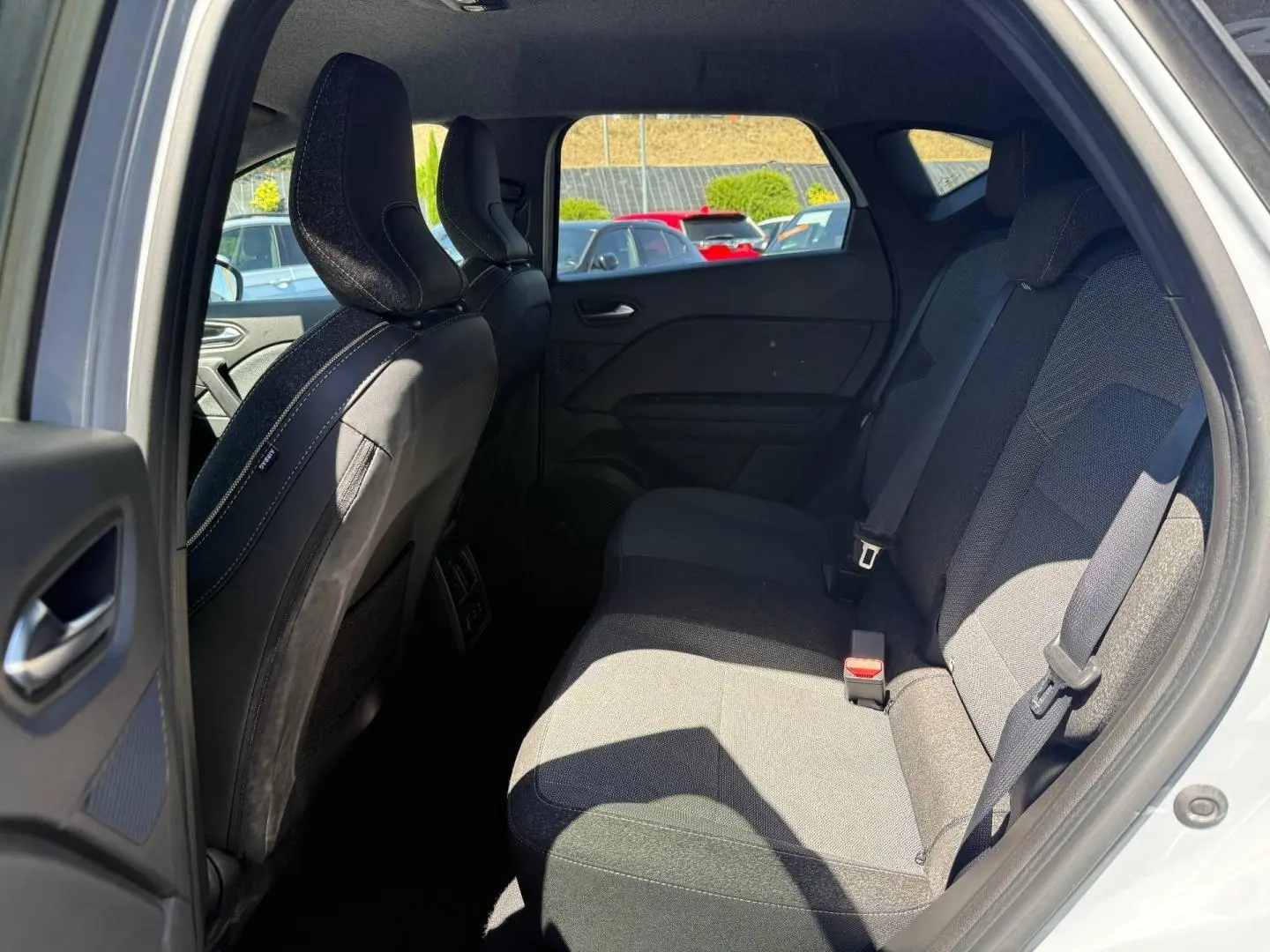 Vue intérieure côté droit des sièges arrière gris foncé du Renault Captur 2025, avec ceintures de sécurité visibles.