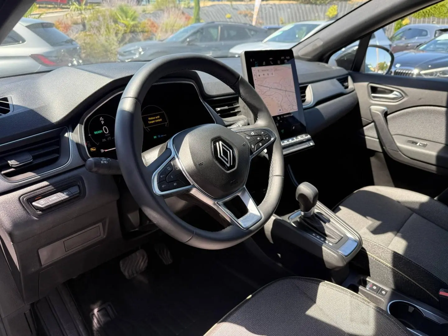Intérieur Renault Captur 2025 vu côté conducteur, volant multifonction et écran tactile vertical en évidence.