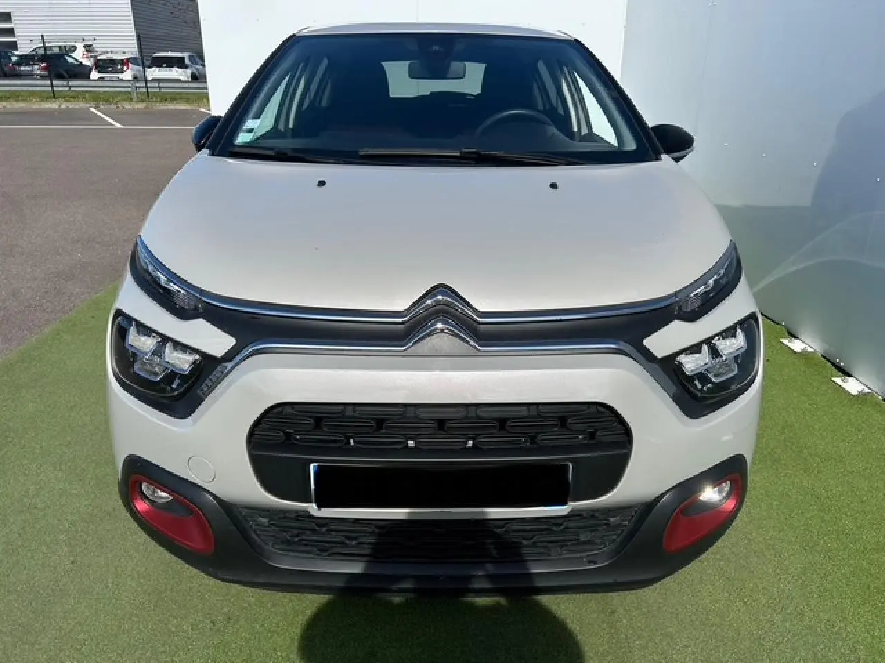 Vue frontale d'une Citroën C3 1.2 PureTech 83 S&S C-Series sable métal avec inserts rouges sur le pare-chocs.