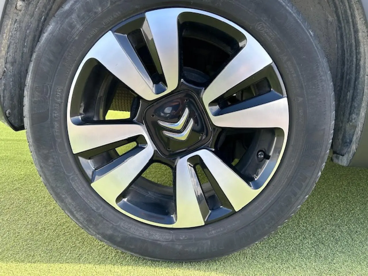 Gros plan sur la jante alliage diamantée 16 pouces noire et argentée d'une Citroën C3 sable métal.