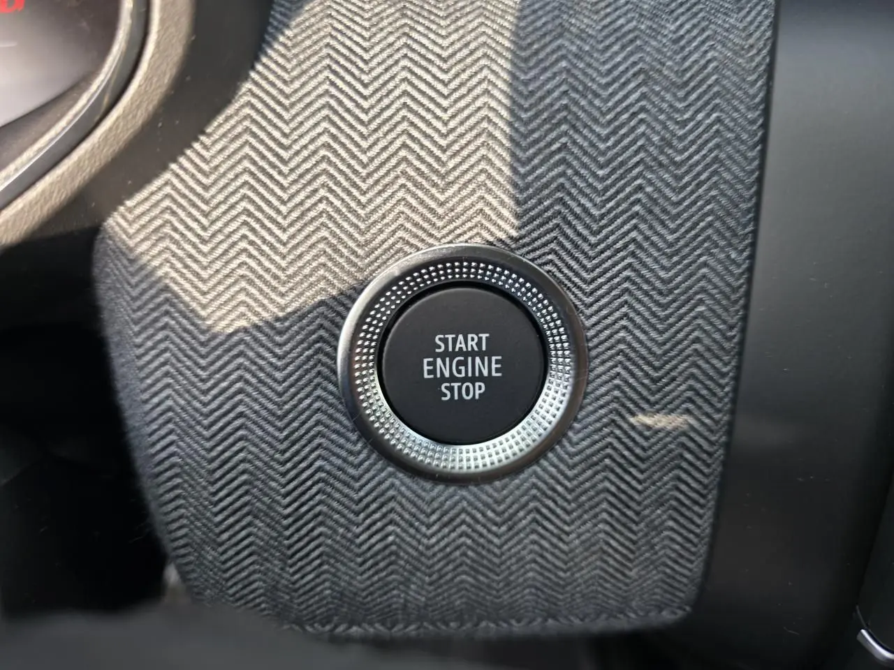 Bouton Start Engine Stop en gros plan sur console avec finition tissu gris à chevrons dans Renault Clio Gris Rafale Metal.