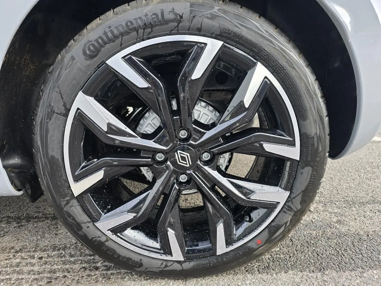 Gros plan sur la jante alliage 17 pouces noir et argent de la Renault Clio V Gris Rafale, avec logo Renault central.