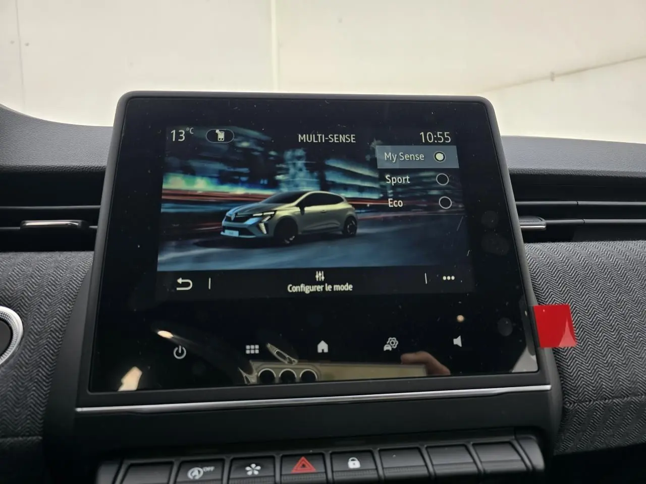 Écran tactile intérieur montrant la Renault Clio V gris Rafale en vue 3/4 avant dans le mode Multi-Sense.