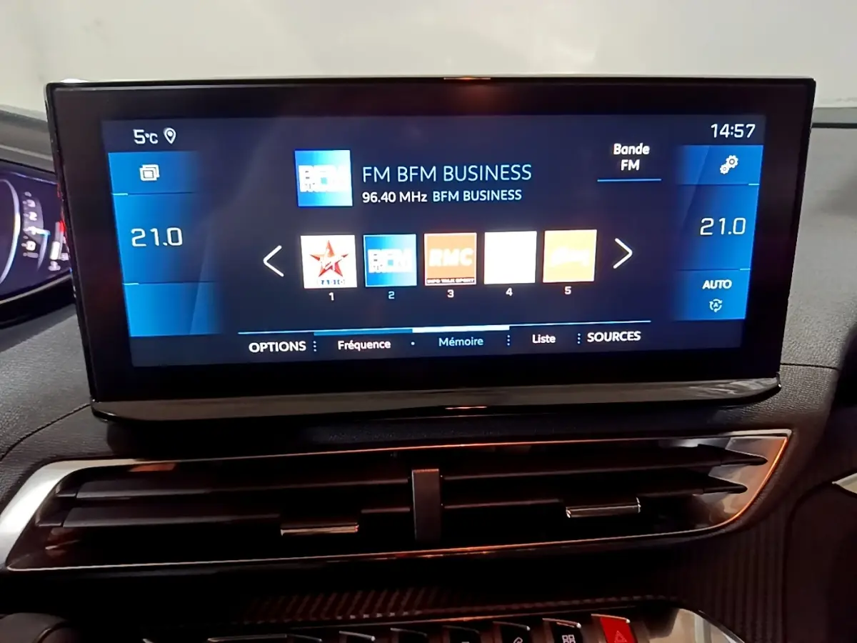 Écran tactile central du tableau de bord du Peugeot 5008 noir, affichant la radio FM BFM Business.