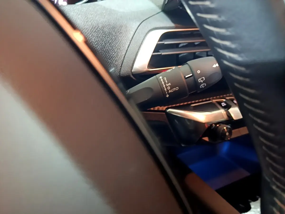 Détail intérieur du Peugeot 5008 noir 2021 montrant la commande d’essuie-glace côté gauche près du volant cuir.