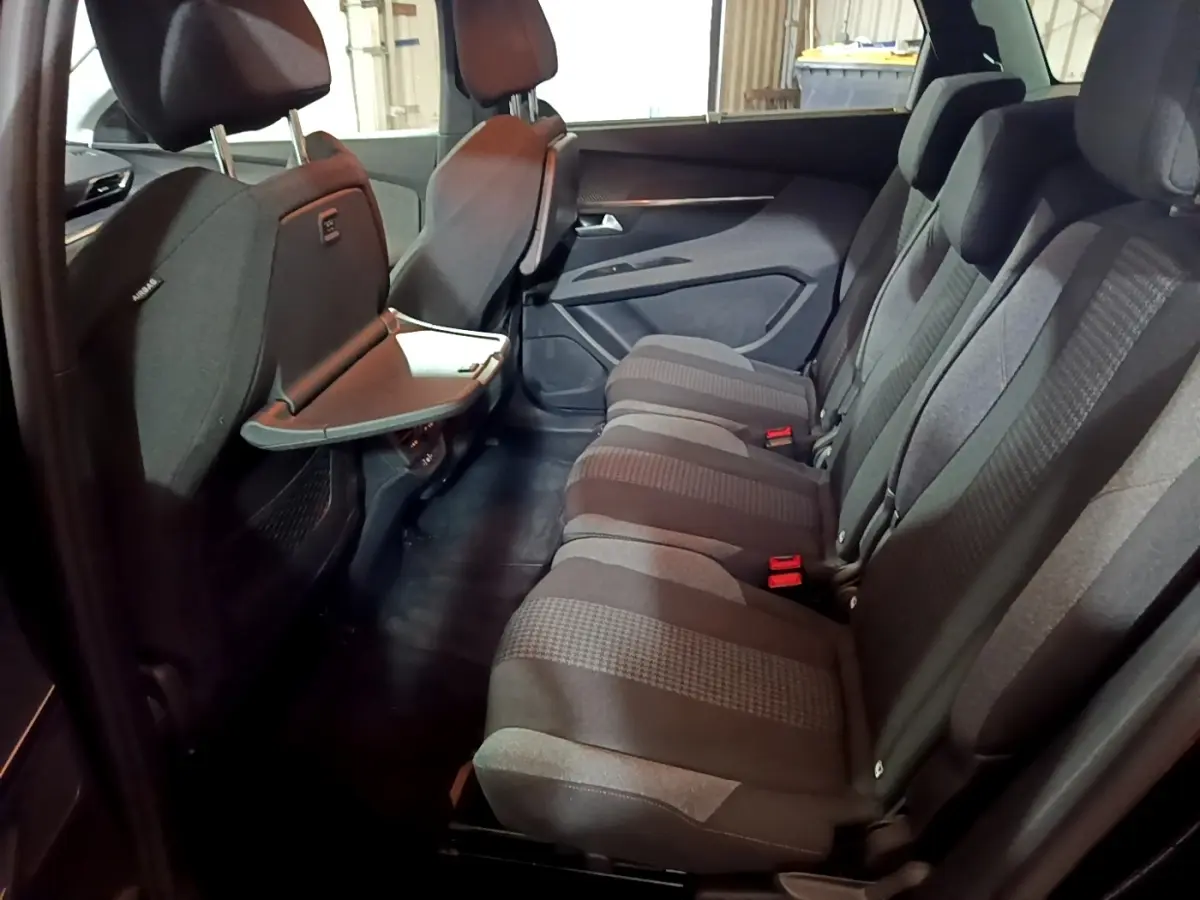 Vue intérieure côté droit des sièges arrière gris foncé du Peugeot 5008 2021 avec tablette rabattable sur dossier avant.