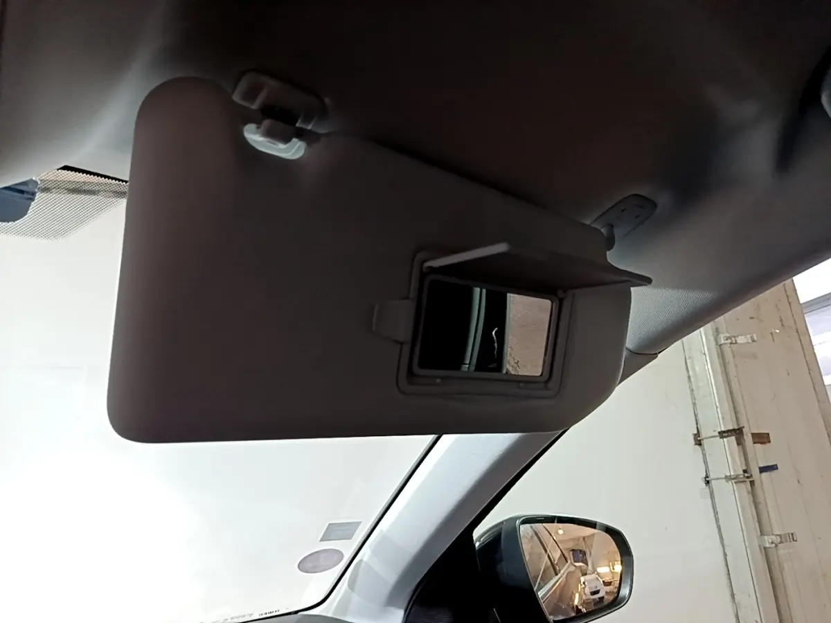 Vue intérieure du pare-soleil côté conducteur avec miroir intégré et rétroviseur extérieur droit visible sur Peugeot 5008 noir.