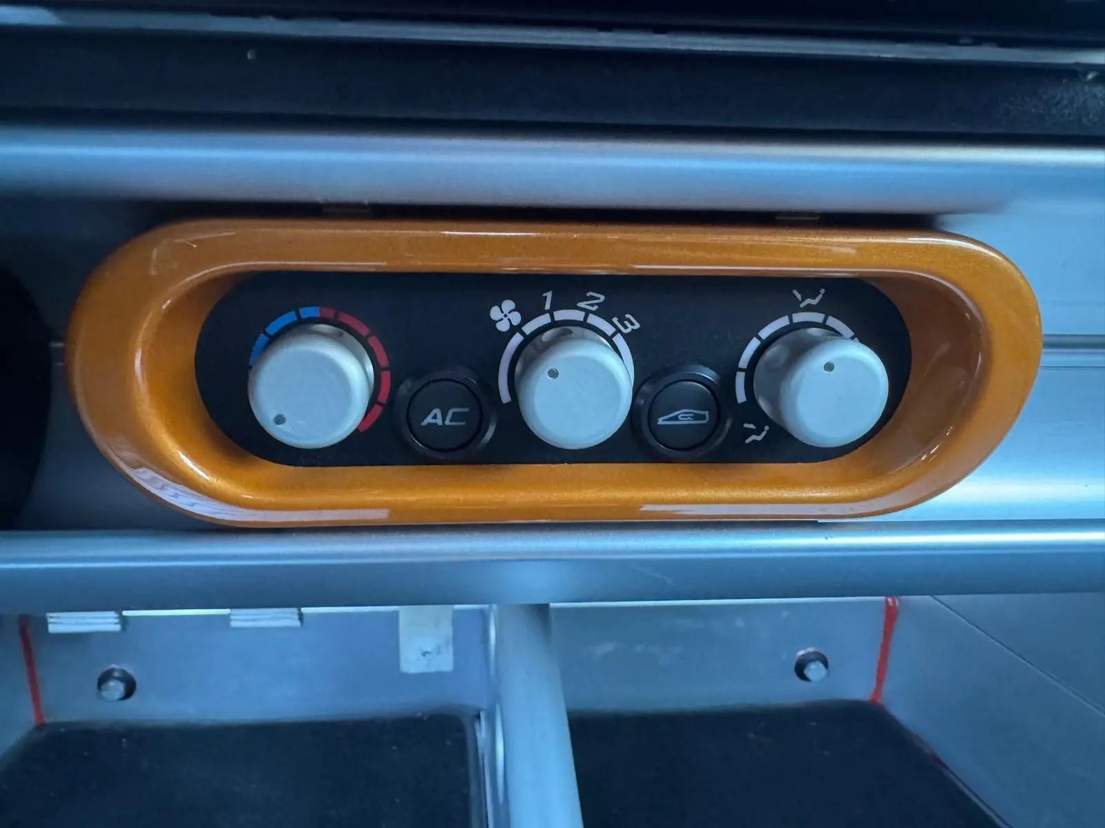 Détail de la commande de climatisation orange sur le tableau de bord de la Lotus Elise 3 Cup 250 2021.