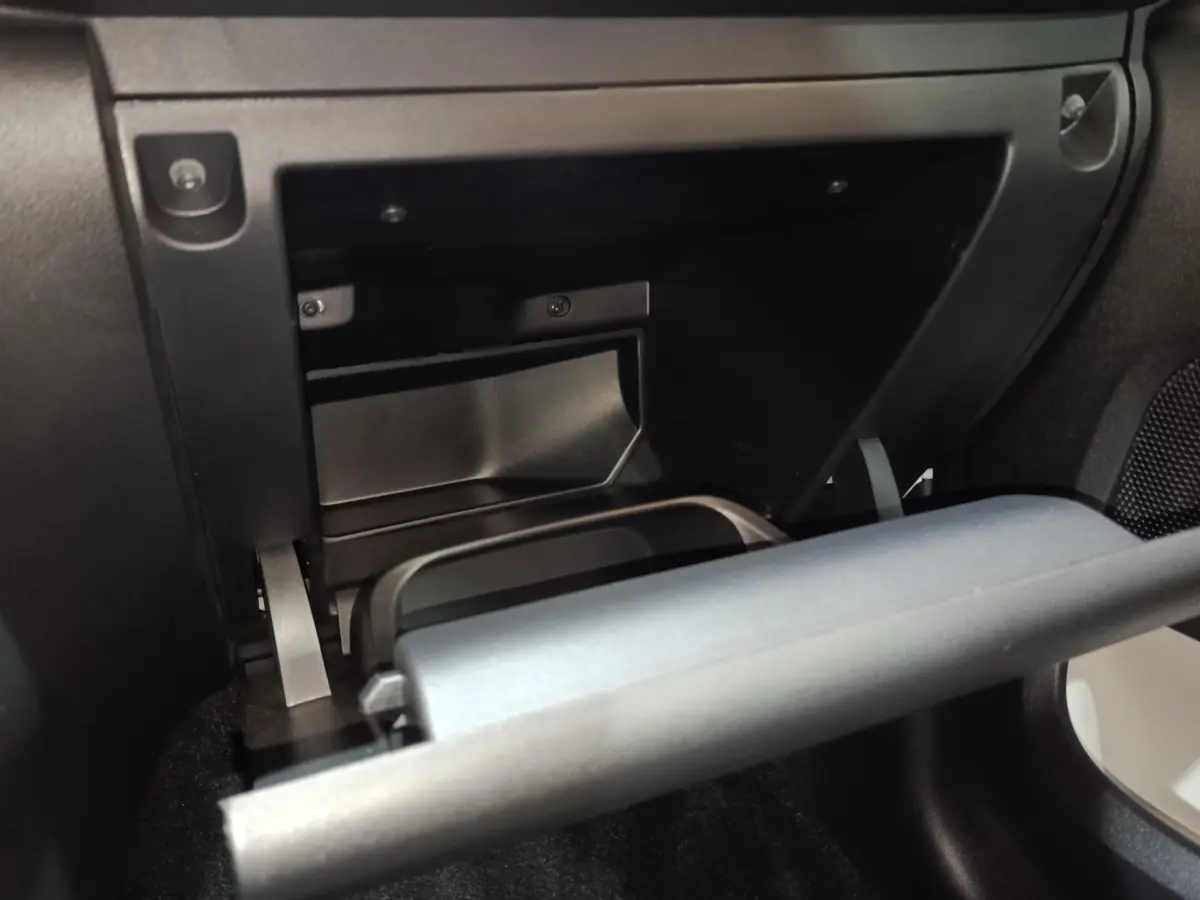 Vue rapprochée de la boîte à gants ouverte côté passager dans l'habitacle noir de la Citroën C3 blanche 2020.