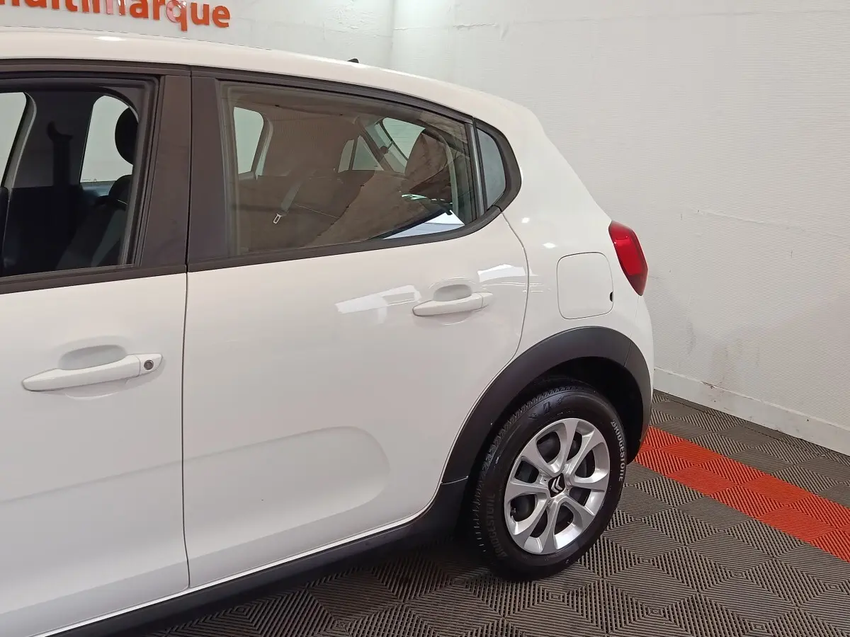 Vue côté droit arrière d'une Citroën C3 blanche 2020 avec jantes alliage et protections noires sur les passages de roues.