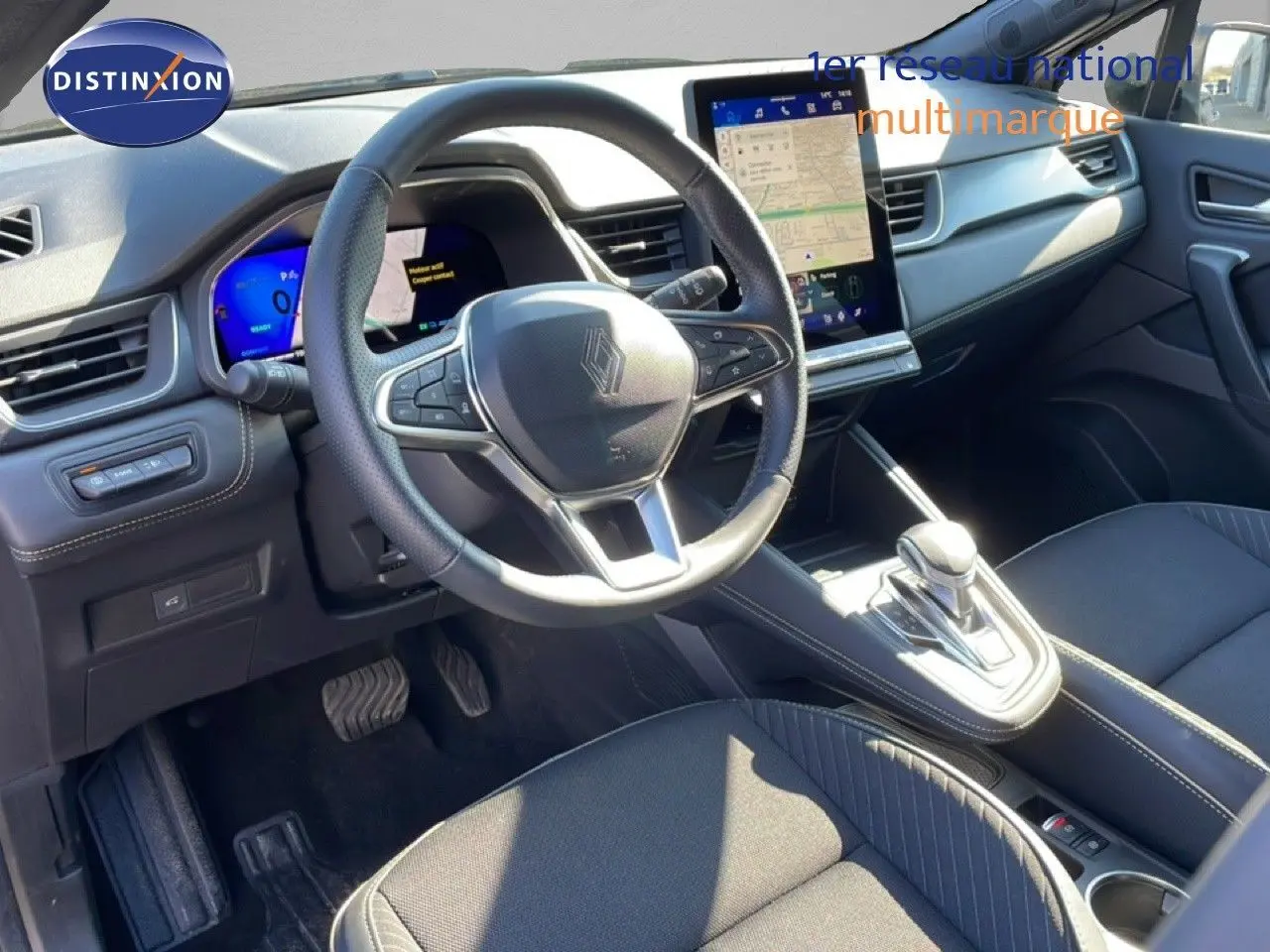 Vue intérieure côté conducteur de la Renault Symbioz noire étoile métal, avec volant cuir et écran tactile central lumineux.