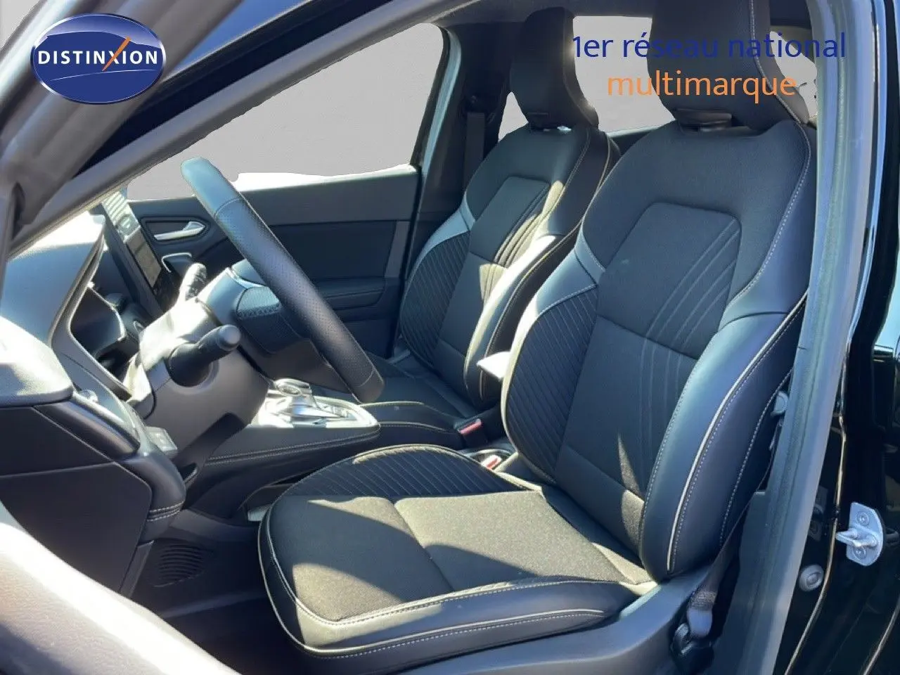 Vue intérieure côté conducteur du Renault Symbioz 2025 noir étoile métal, sièges tissu et cuir avec surpiqûres blanches.