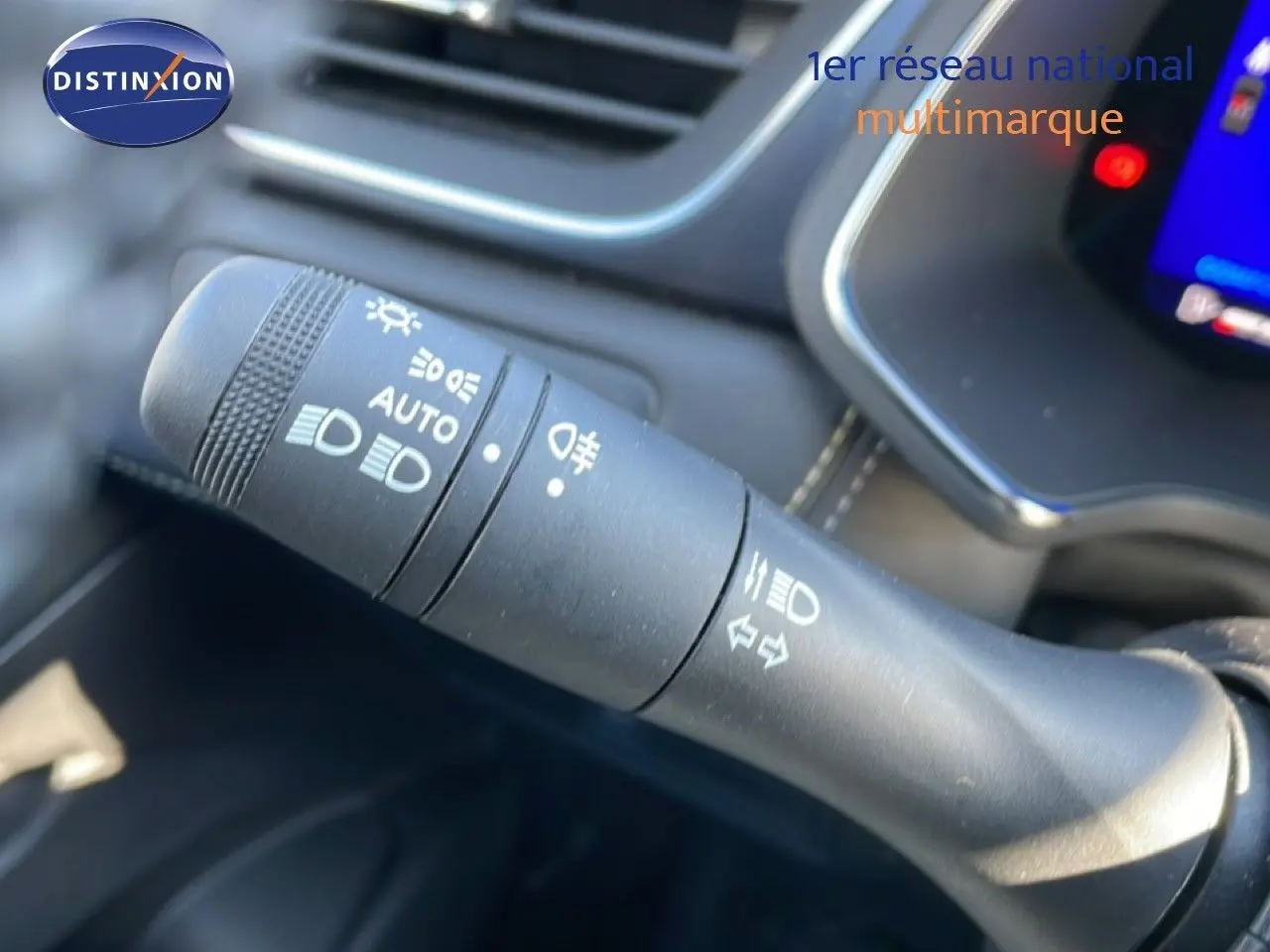 Gros plan sur la commande des phares à gauche du volant dans l’habitacle noir du Renault Symbioz 2025.