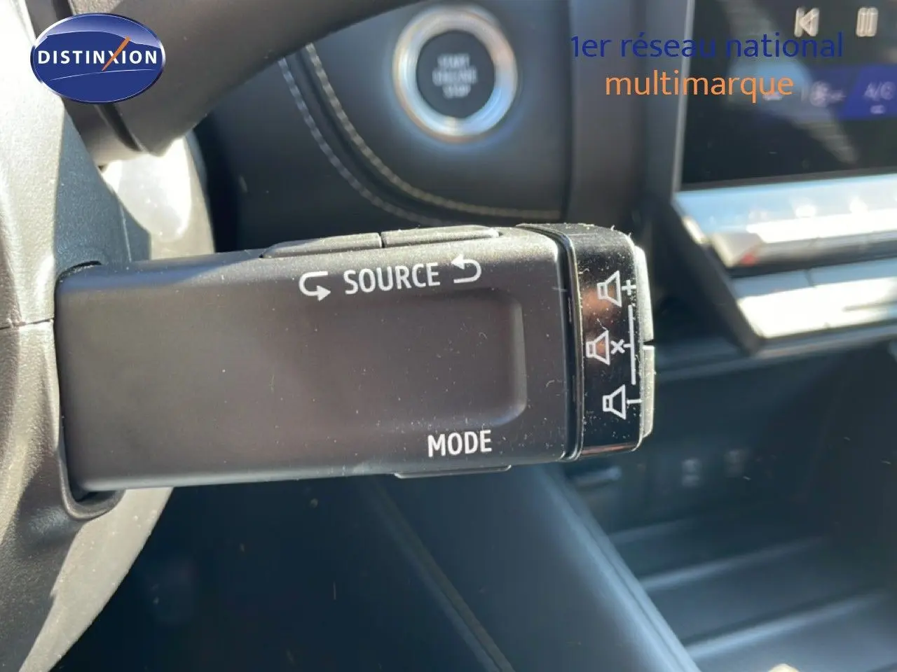Gros plan sur la commande multimédia au volant du Renault Symbioz noir étoile métal, avec tableau de bord en arrière-plan.