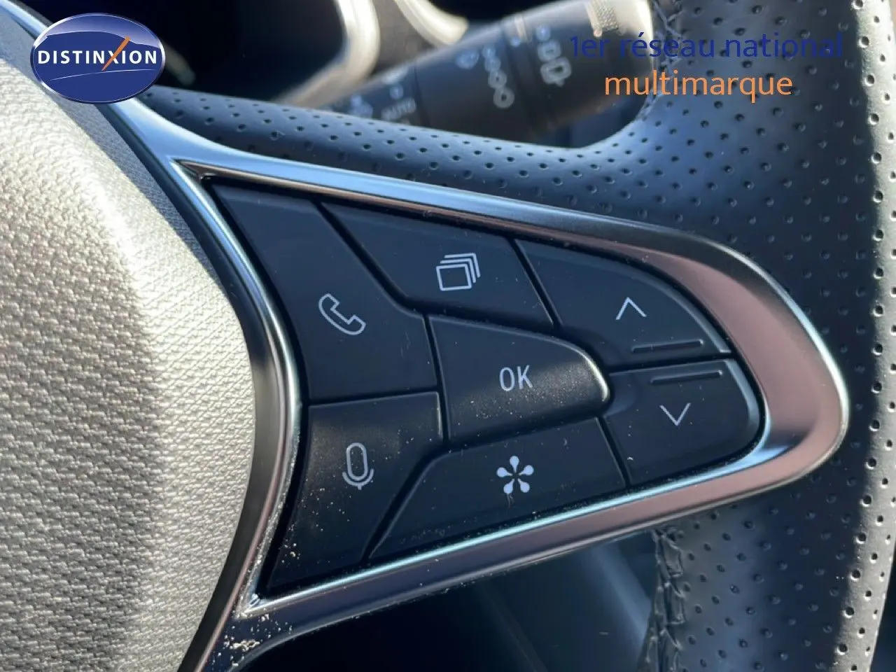 Gros plan sur les commandes multifonctions du volant perforé du Renault Symbioz noir étoile métal 2025.