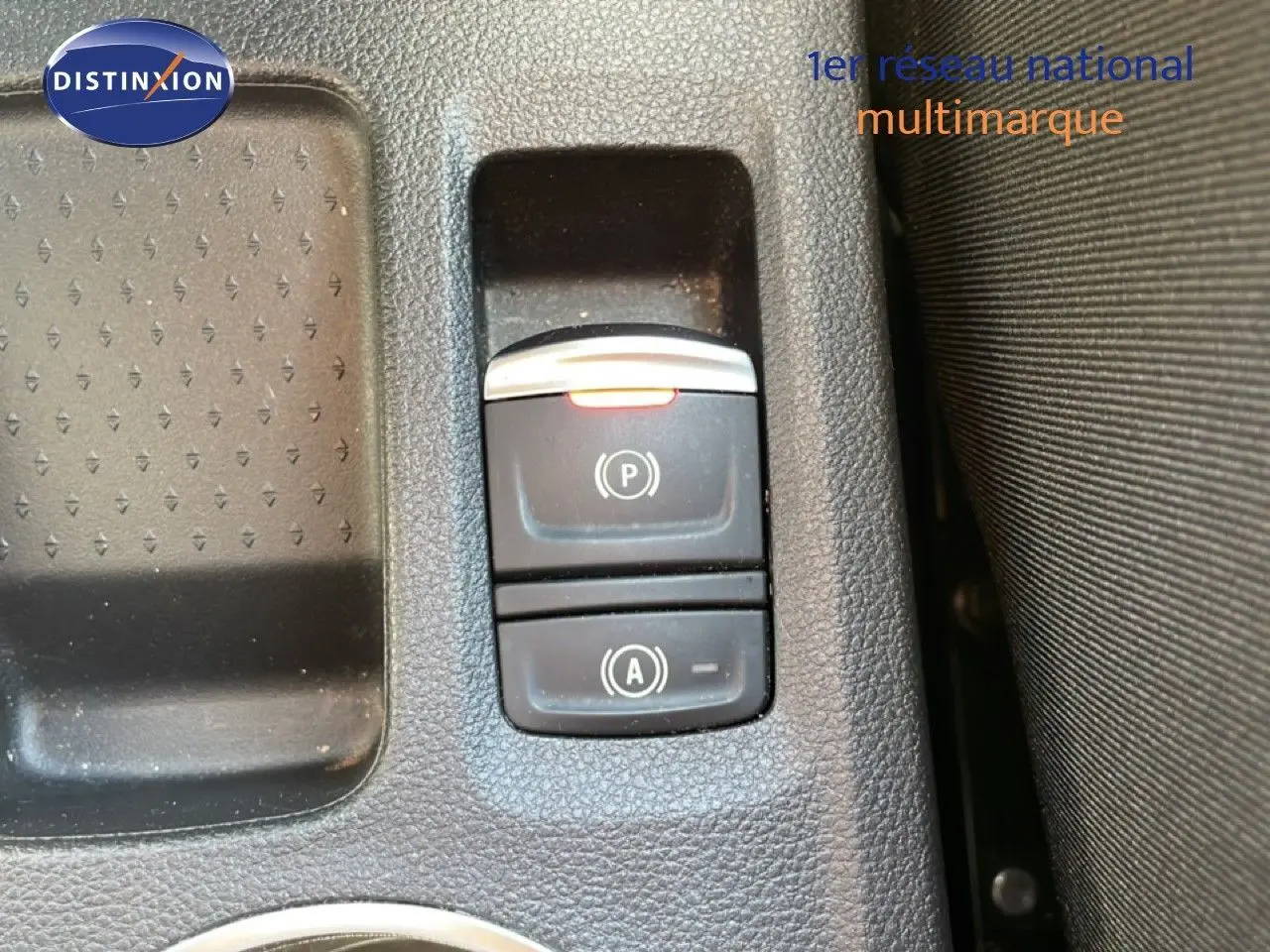 Gros plan sur les commandes de frein à main électronique et auto hold dans l'habitacle du Renault Symbioz noir étoile métal.
