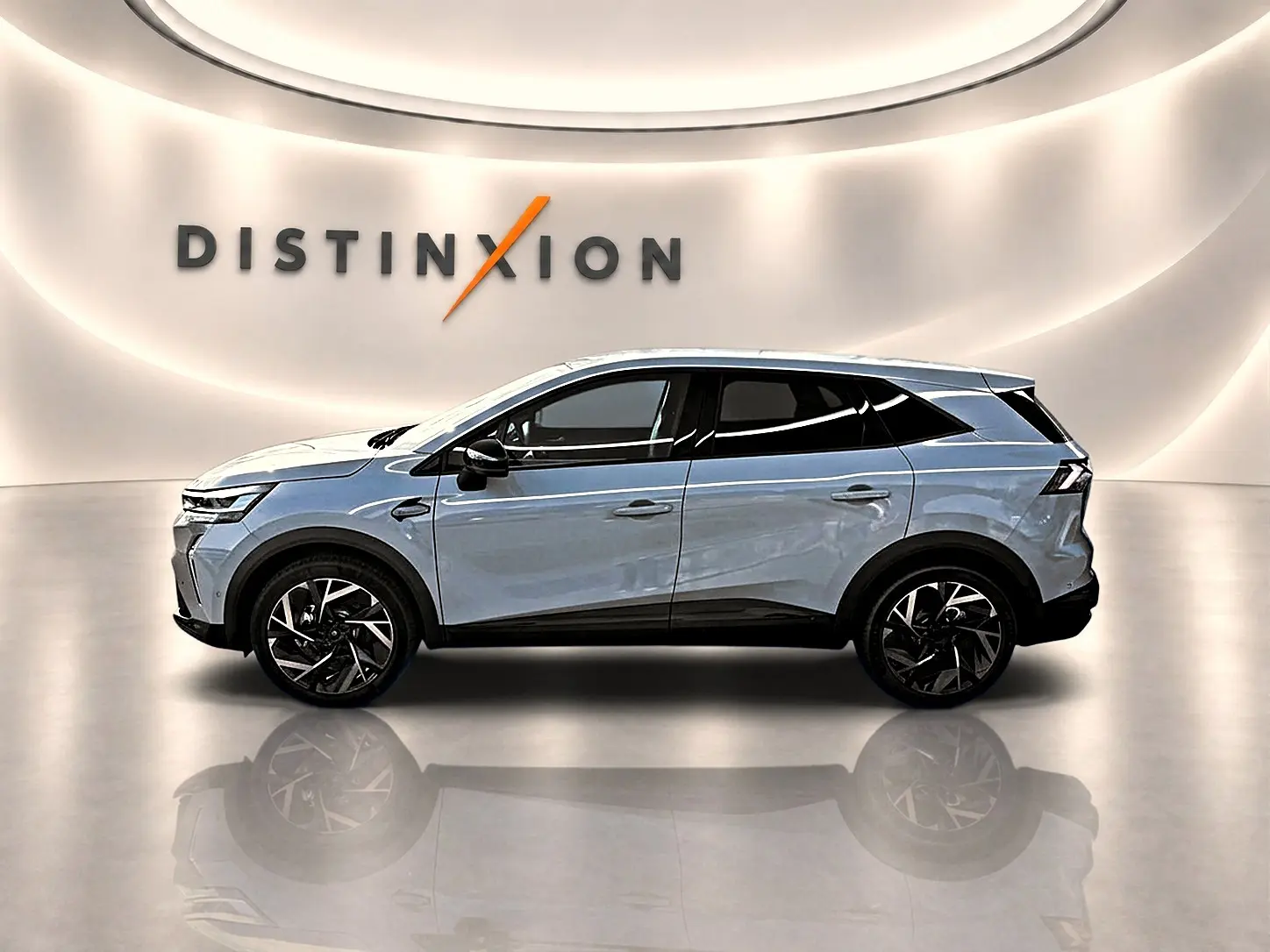 Vue de profil côté gauche du Renault Symbioz gris rafale, avec jantes alu noires et toit blanc dans un showroom lumineux.