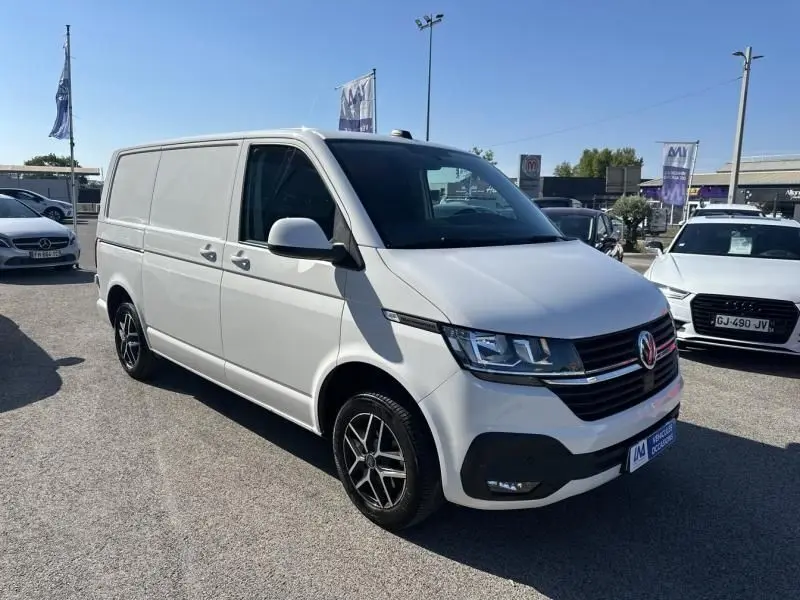 Vue 3/4 avant d'un Volkswagen Transporter blanc 2.0 TDI 150 Business 2022 avec jantes alliage noires.
