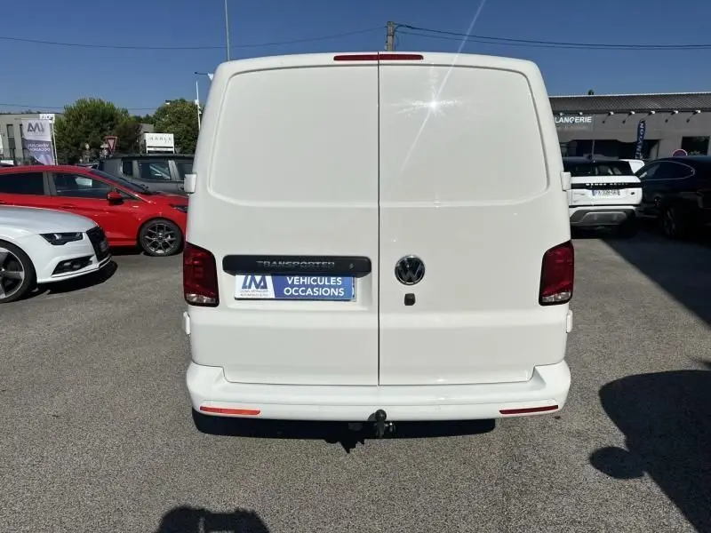 Vue arrière d'un Volkswagen Transporter blanc 2.0 TDI 150 Business 2022 stationné en extérieur sur parking.