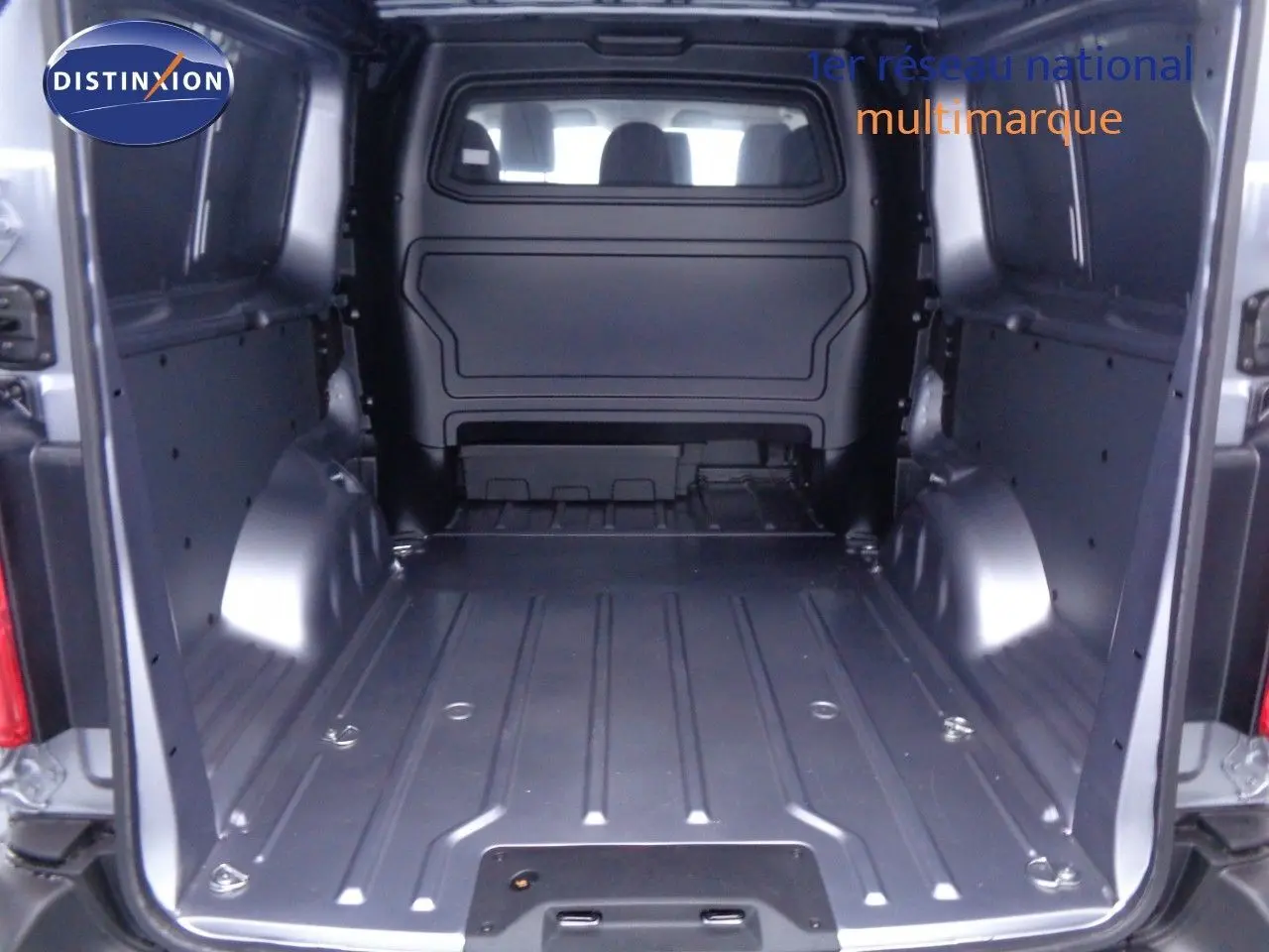 Vue arrière de la cabine approfondie grise du Peugeot Expert Long 2023, montrant l'espace de chargement vide et métallique.