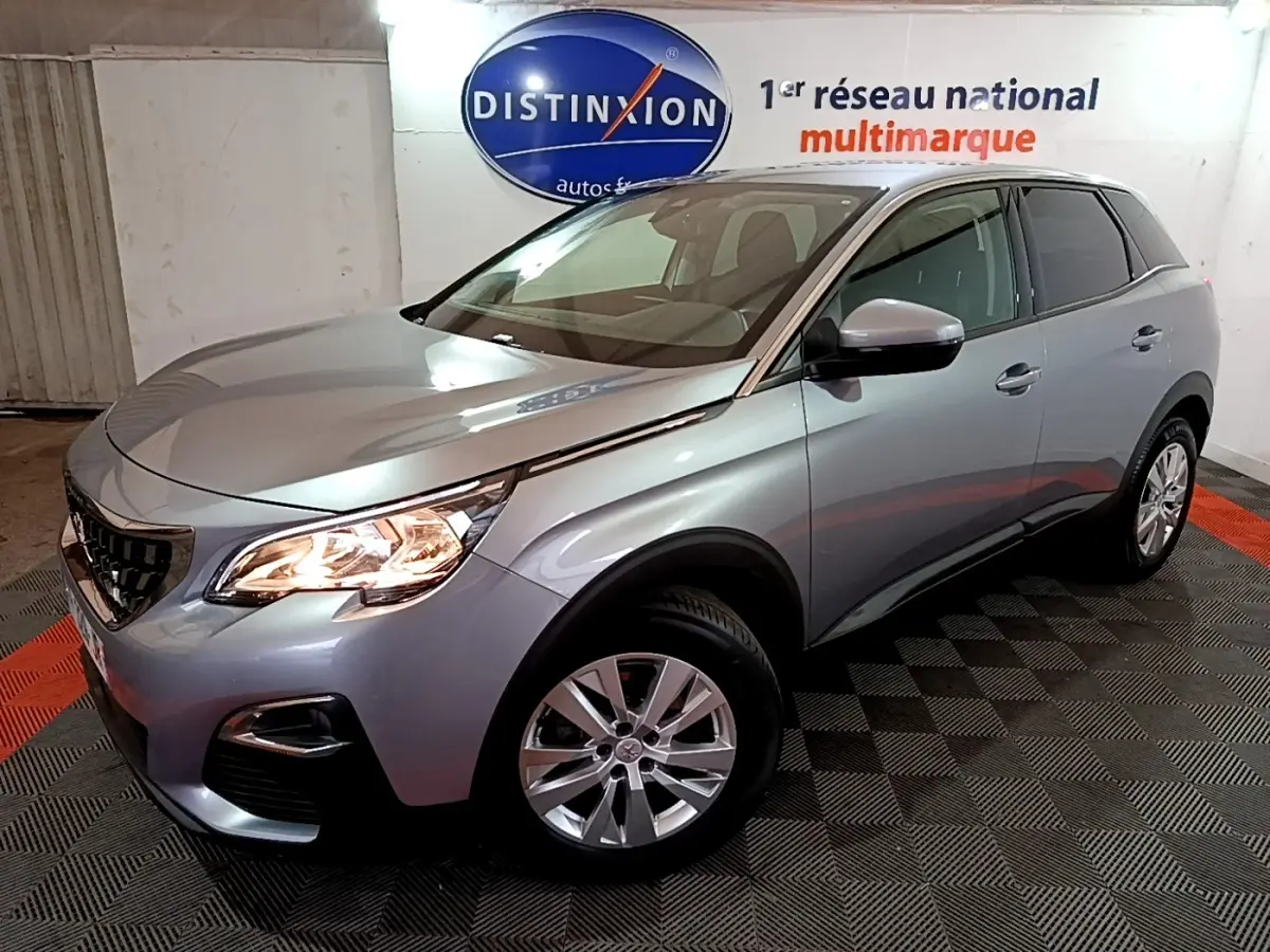 Vue 3/4 avant droit d’un Peugeot 3008 gris clair avec phares allumés dans un showroom.