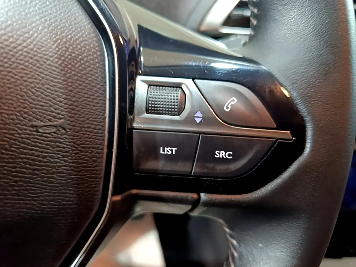 Gros plan sur les commandes gauche du volant cuir noir du Peugeot 3008 gris clair, version Puretech 130 S&S Active Business.