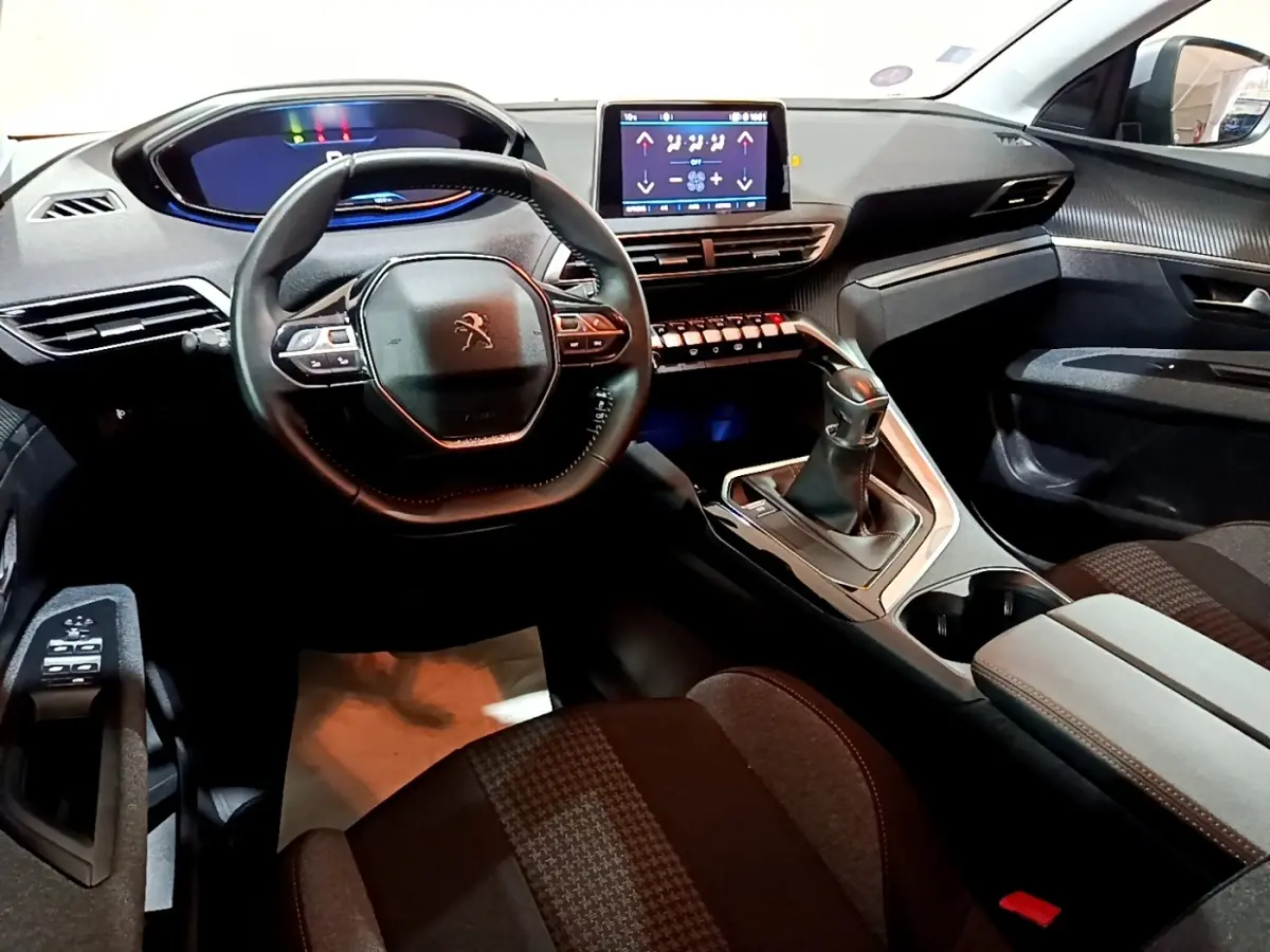 Vue intérieure avant du Peugeot 3008 gris clair 2020, mettant en valeur le volant cuir, l’écran tactile et la boîte manuelle.