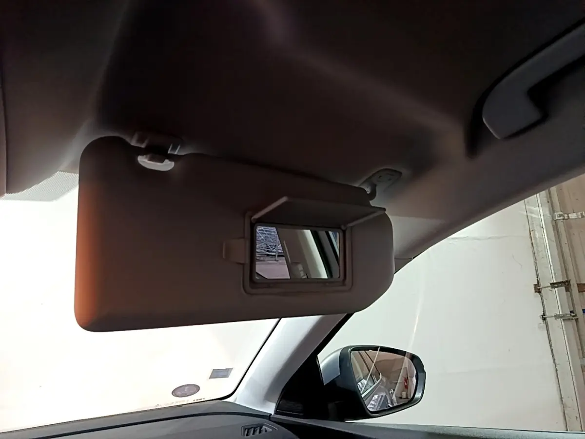 Détail du pare-soleil côté conducteur avec miroir intégré dans l’habitacle d’un Peugeot 3008 gris clair.