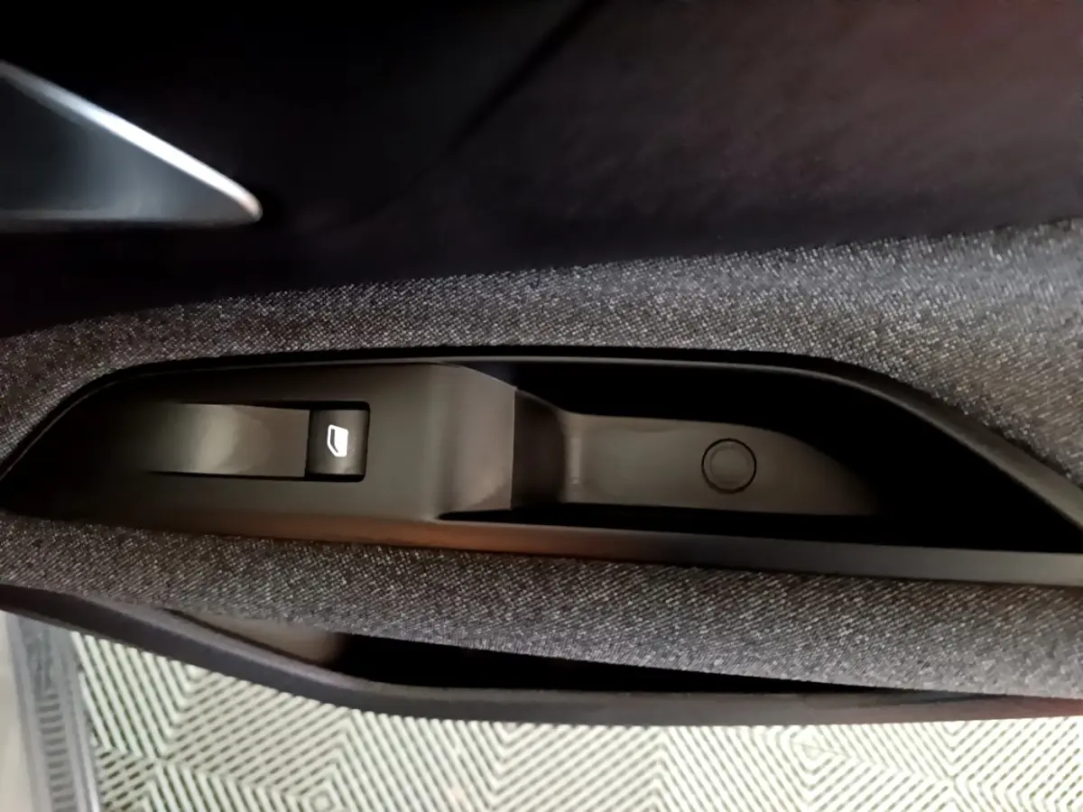 Bouton de commande de lève-vitre électrique sur la porte intérieure côté conducteur du Peugeot 3008 gris clair.