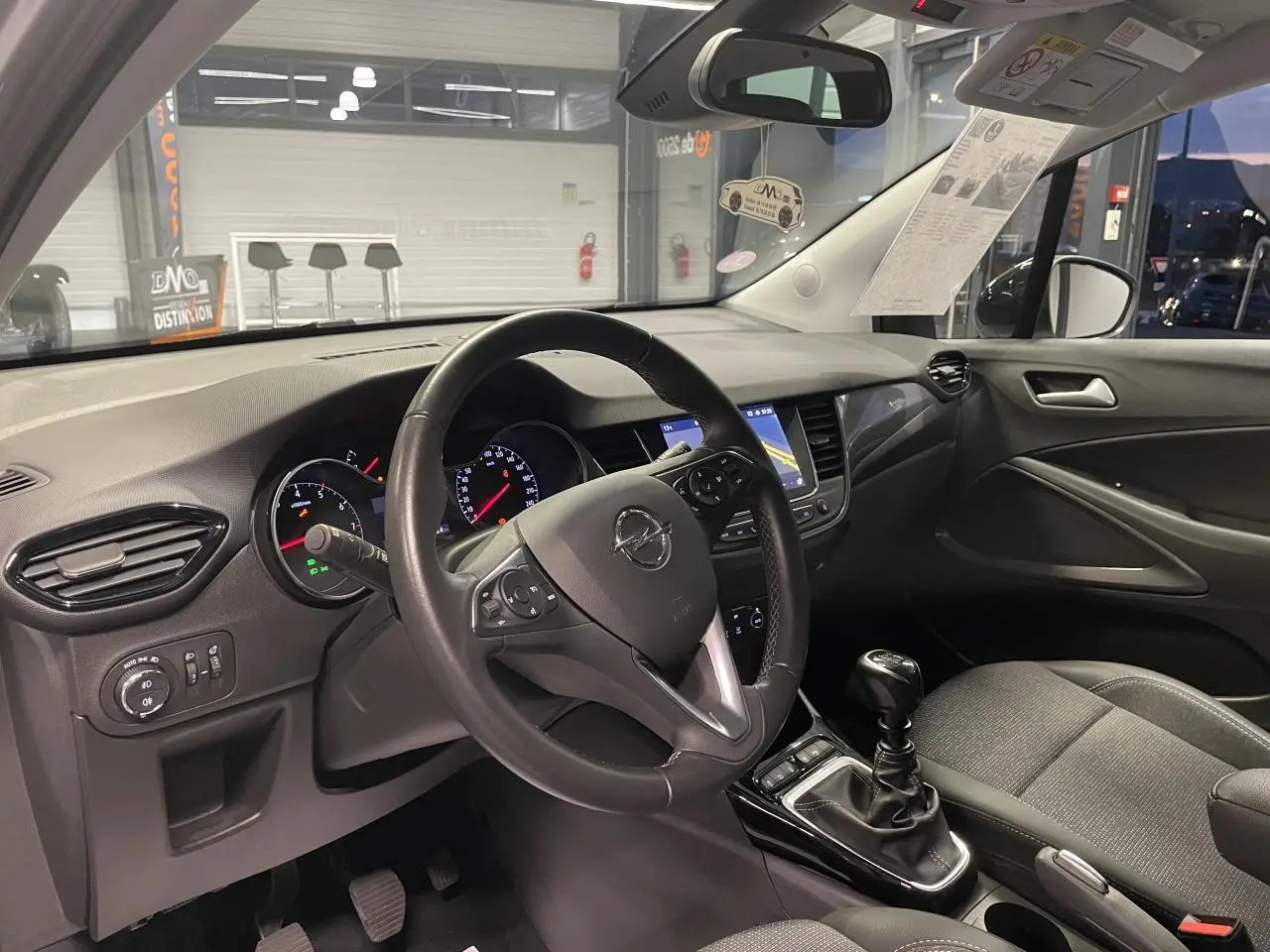 Vue intérieure côté conducteur de l’Opel Crossland 2024, volant cuir et tableau de bord avec écran tactile.