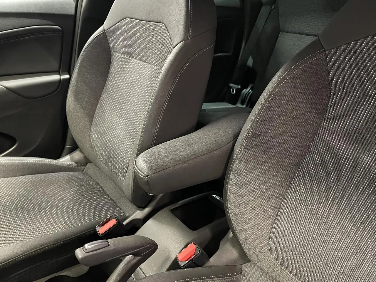 Gros plan sur les sièges avant gris tissu avec accoudoir central du côté droit de l’Opel Crossland 2024.