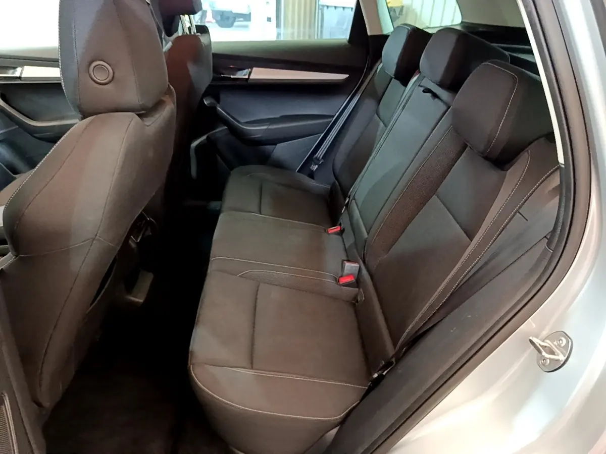 Vue intérieure côté droit des sièges arrière noirs du Skoda Karoq 1.5 TSI 2022 avec ceinture de sécurité visible.
