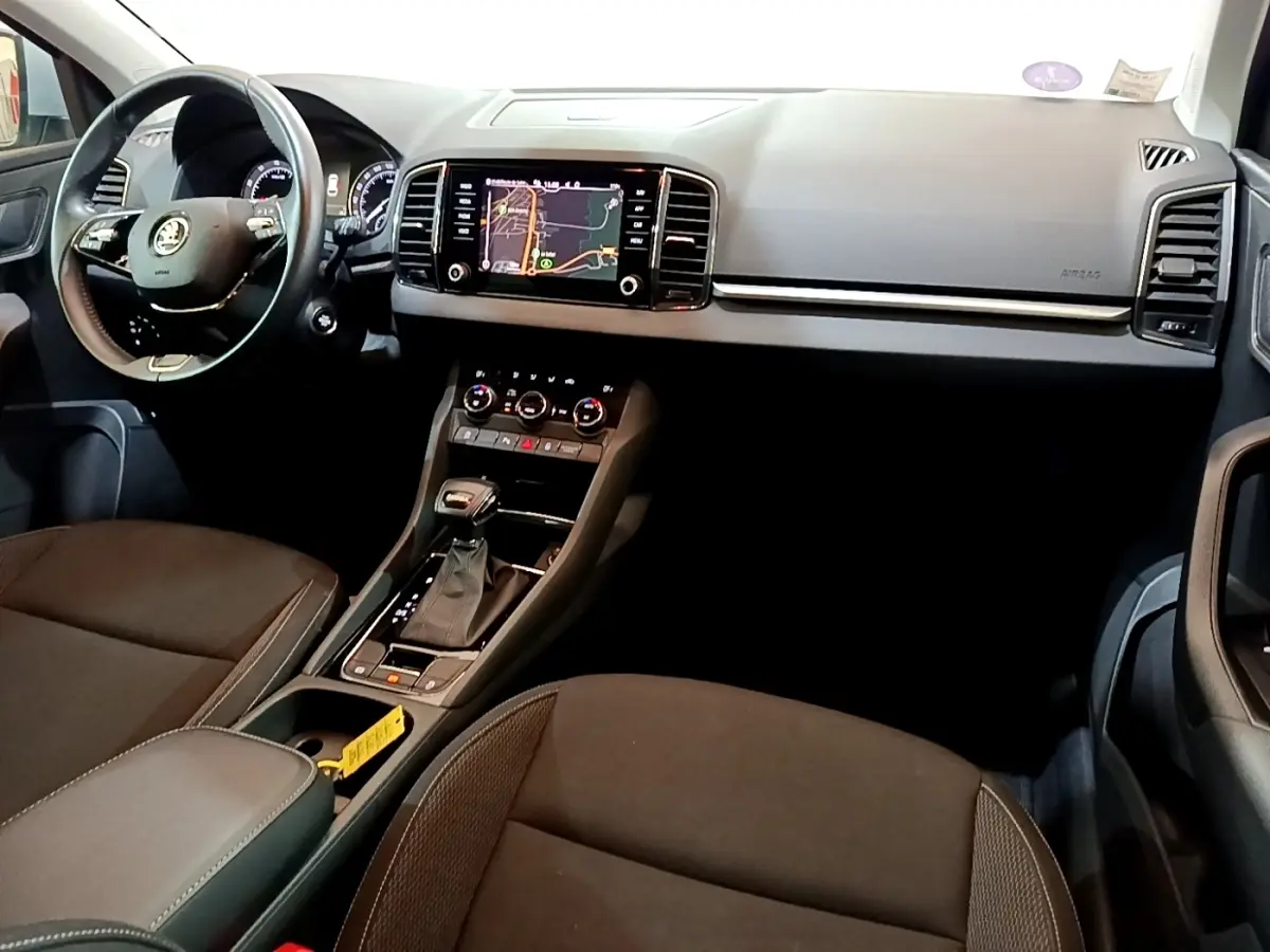 Vue intérieure du tableau de bord et console centrale du Skoda Karoq 2022 avec écran tactile et volant multifonctions.