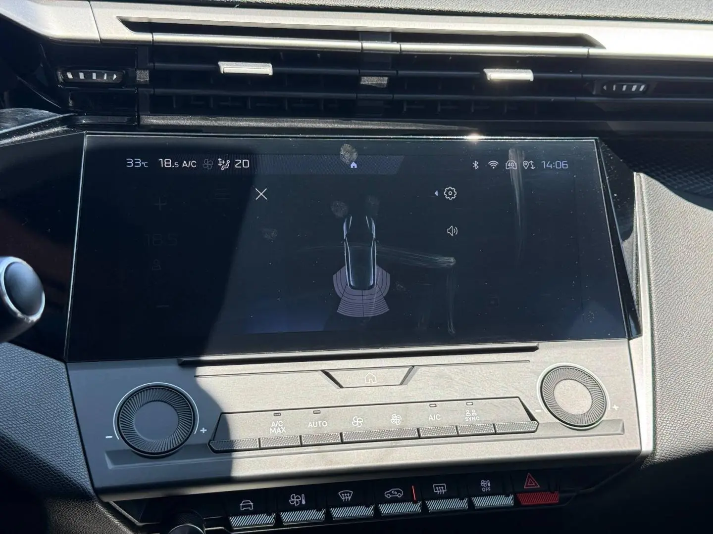 Vue rapprochée de l’écran tactile central et commandes grises du tableau de bord de la Peugeot e-308 noire.