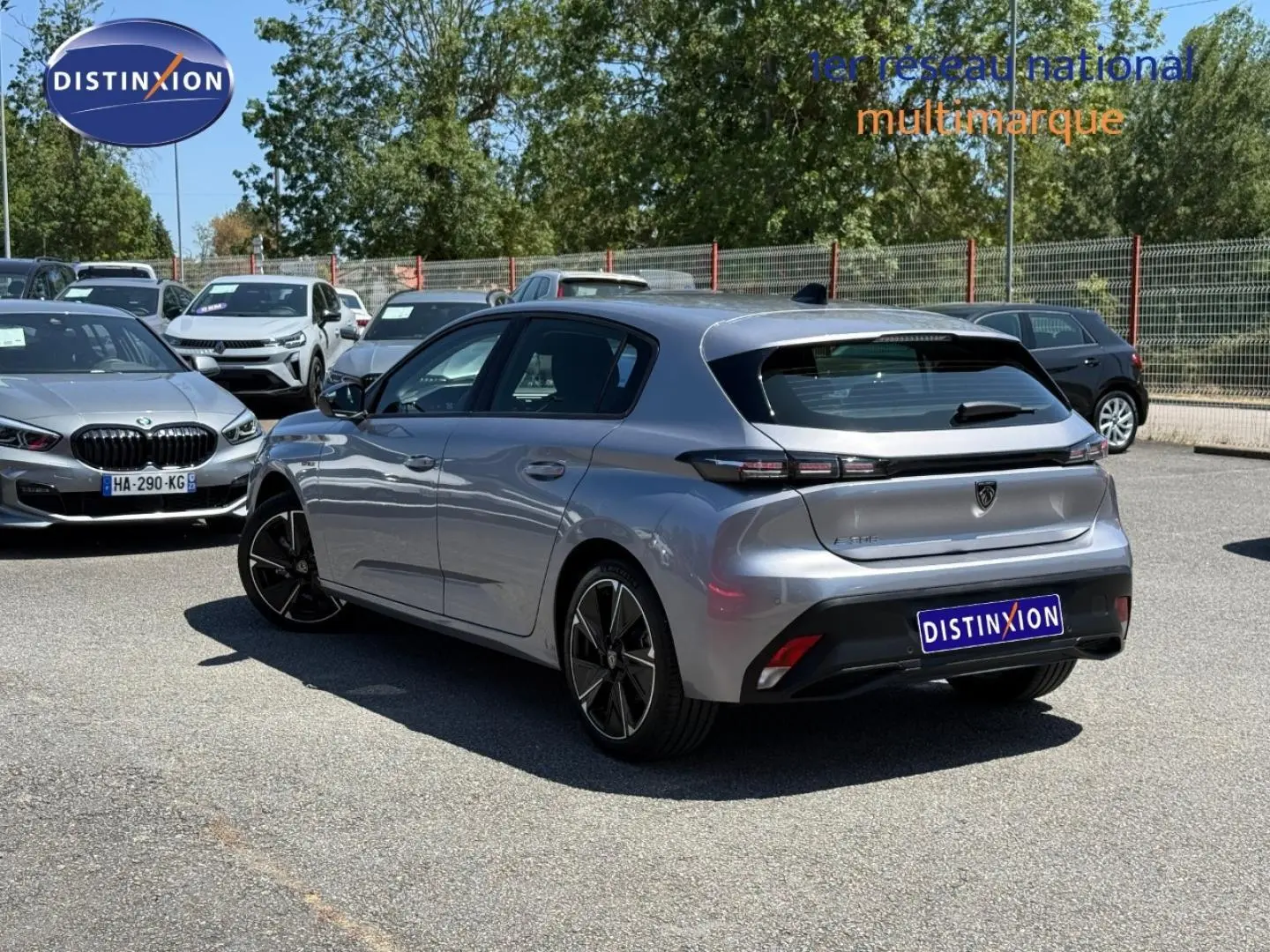 Peugeot e-308 gris métallisé en 3/4 arrière droit, avec feux arrière LED et jantes alliage visibles.