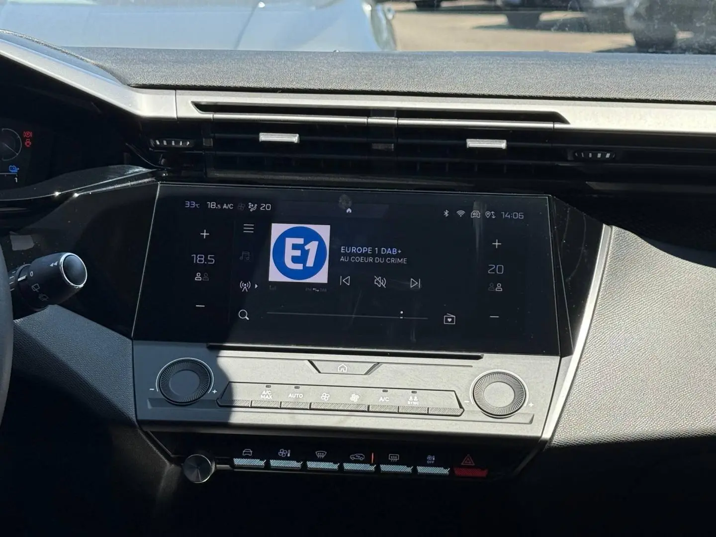 Vue rapprochée de la console centrale tactile de la Peugeot e-308 2025, affichant l’écran multimédia et commandes clim.