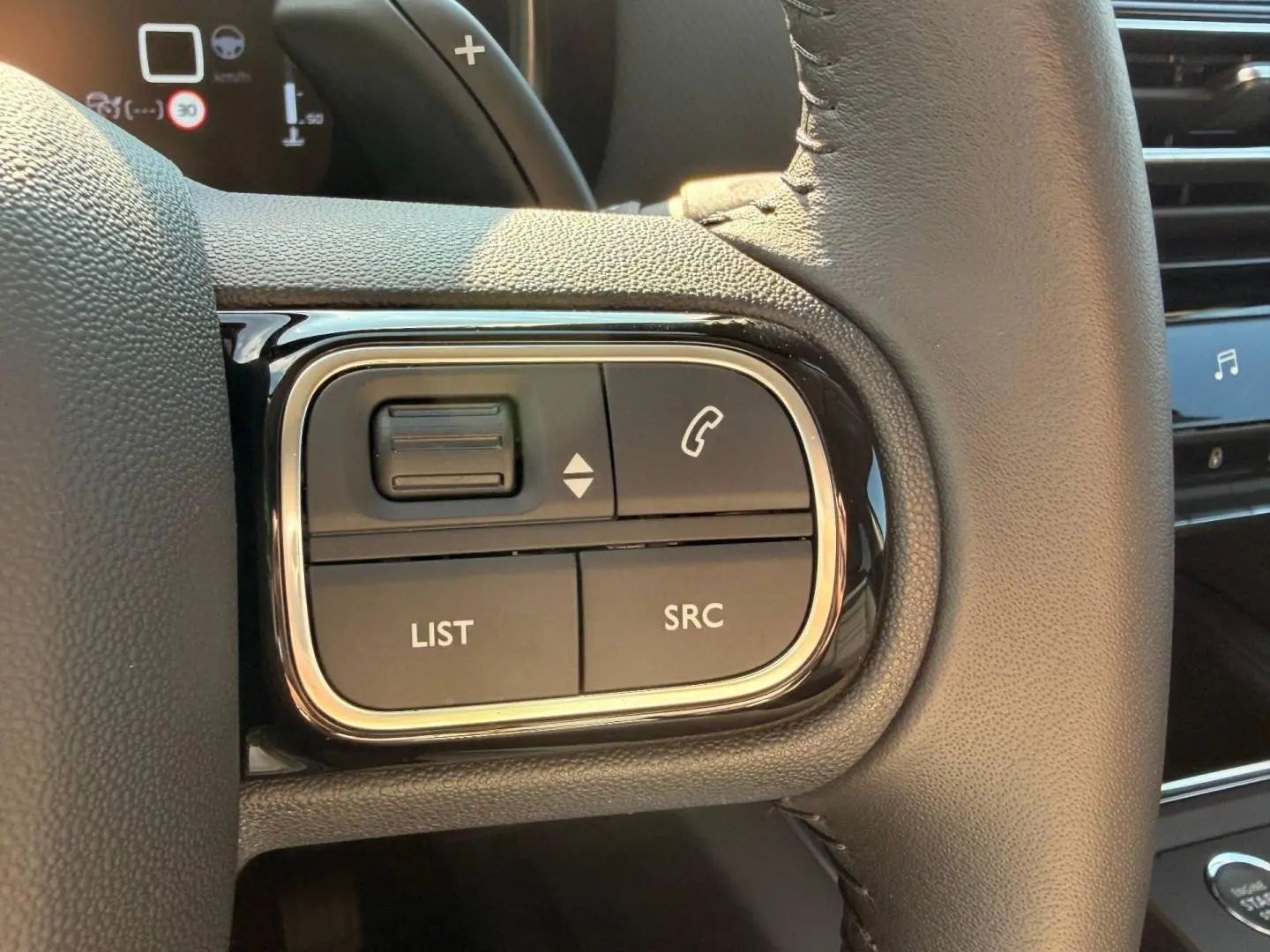 Gros plan sur les commandes multifonctions gauche du volant cuir du Citroën C5 Aircross gris Platinium 2025.