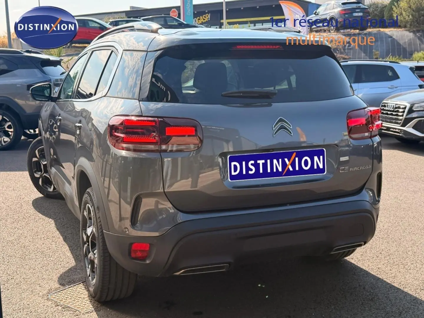 Vue 3/4 arrière d'un Citroën C5 Aircross gris Platinium avec feux arrière LED et jantes alliage noires.