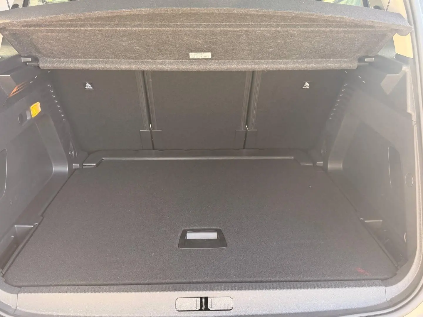 Coffre ouvert vu de l'arrière d'un Citroën C5 Aircross gris Platinium, espace de chargement plat et tapis noir.