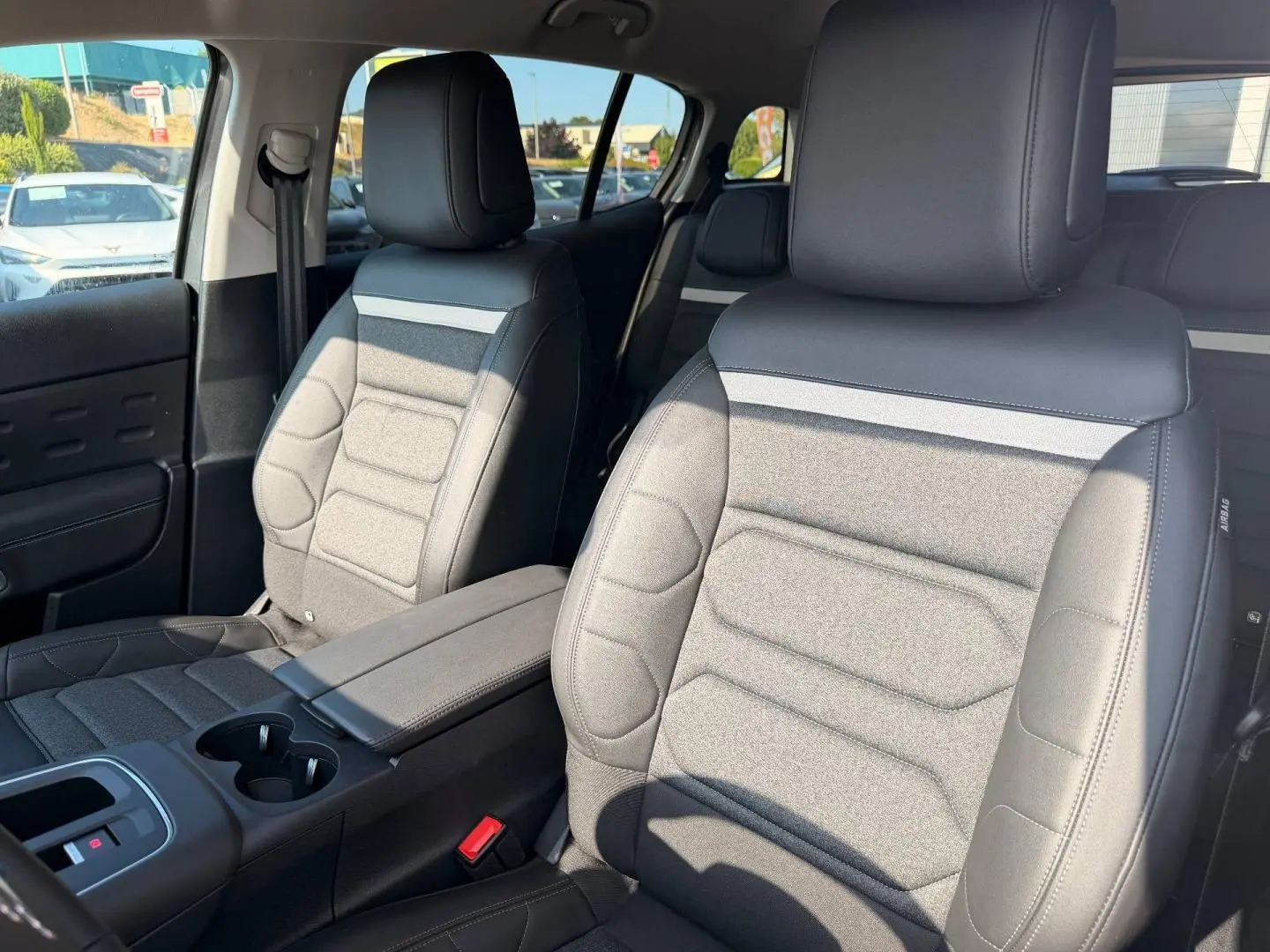 Vue intérieure côté droit des sièges avant en tissu noir et gris du Citroën C5 Aircross 2025 avec accoudoir central.