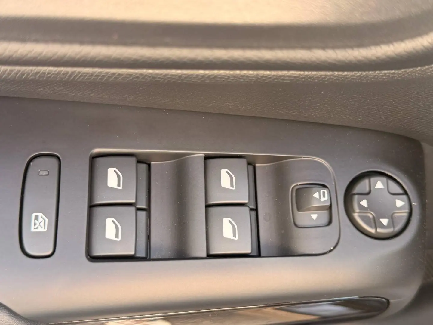 Gros plan sur les commandes de lève-vitres et réglage des rétroviseurs côté conducteur du Citroën C5 Aircross gris Platinium.