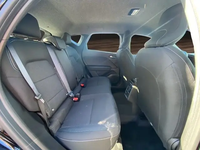Vue intérieure arrière du Renault Captur 2024 noir, montrant la banquette tissu noire et les appuie-têtes arrière.